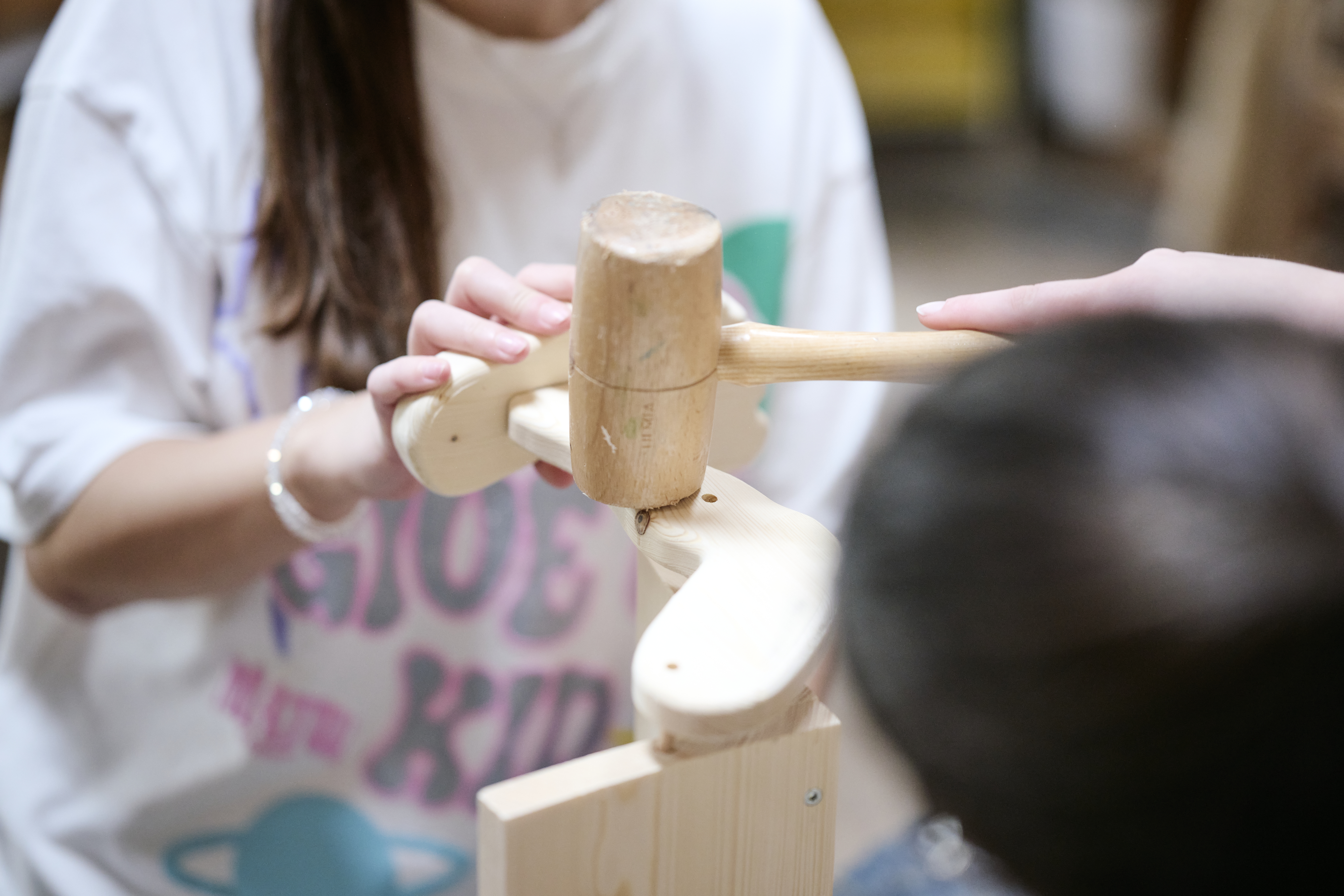 Zwei Personen arbeiten mit Holz. Zwei Personen arbeiten mit Holz.