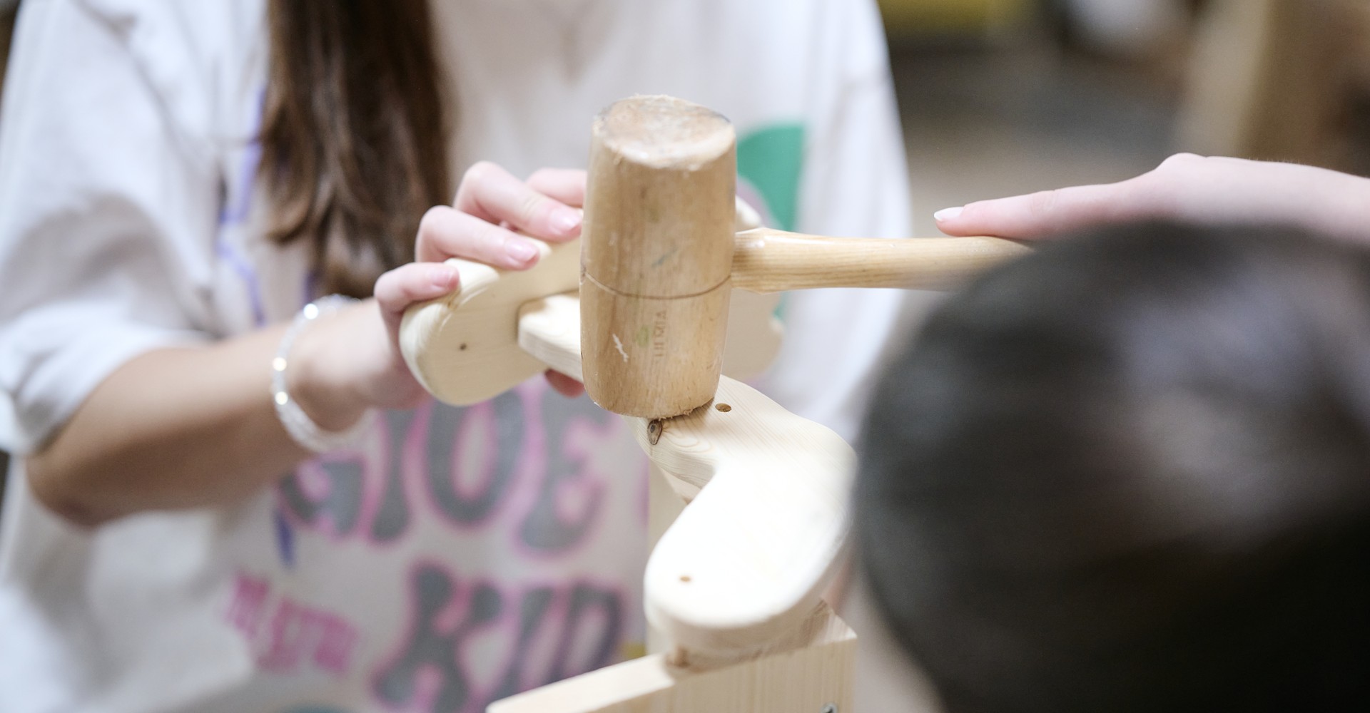 Zwei Personen arbeiten mit Holz.